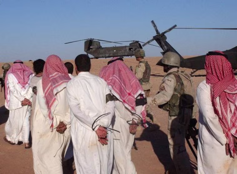 Suspected al-Qaeda terrorists escorted to a POW camp.